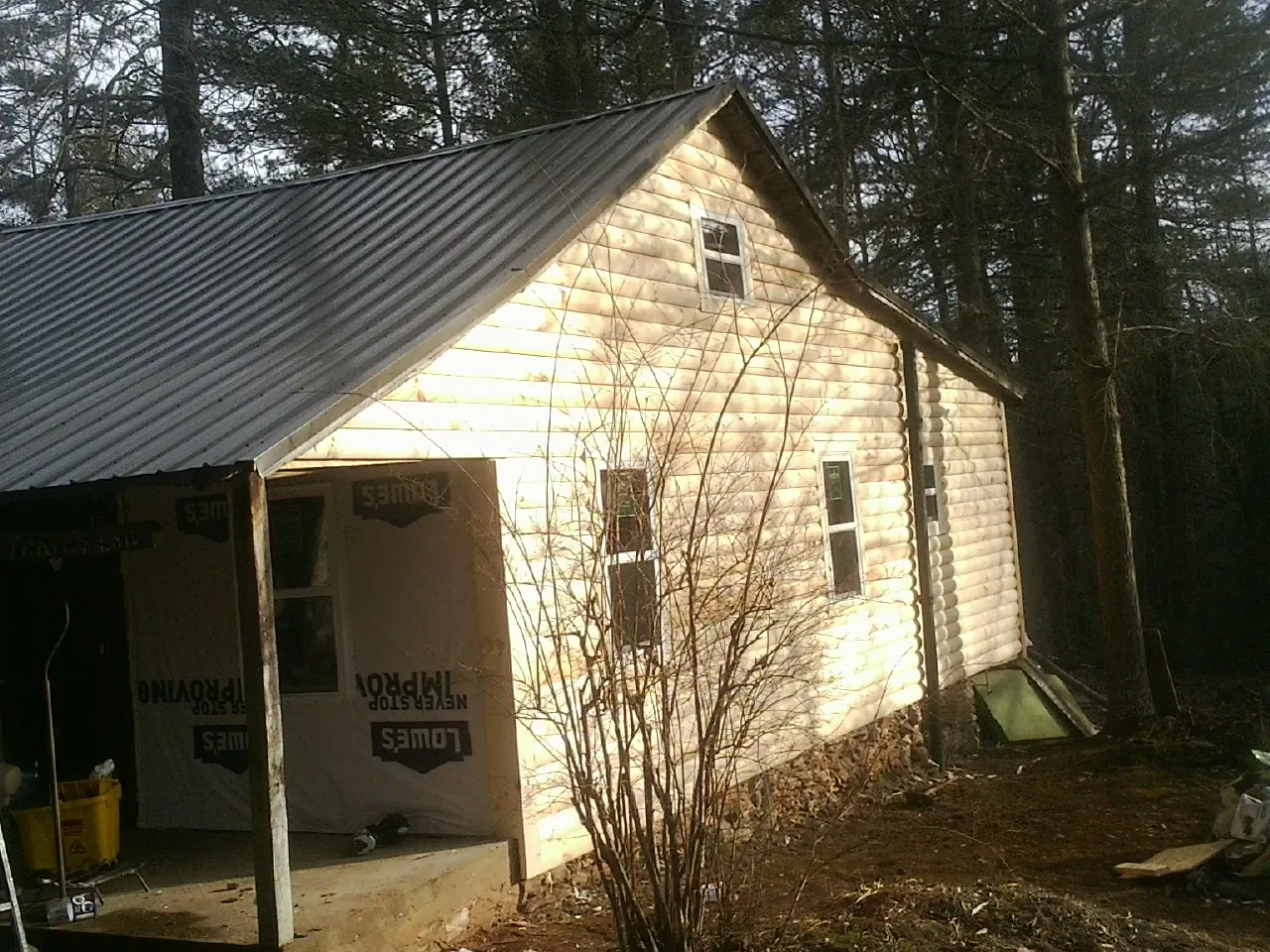 Log siding gable end under a dark metal roof edge in Pleasant Garden