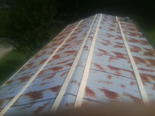 Rusted metal roof panels with new wood purlins before replacement — Storm Damage Roof Repair in Pleasant Garden by Roofing Brothers