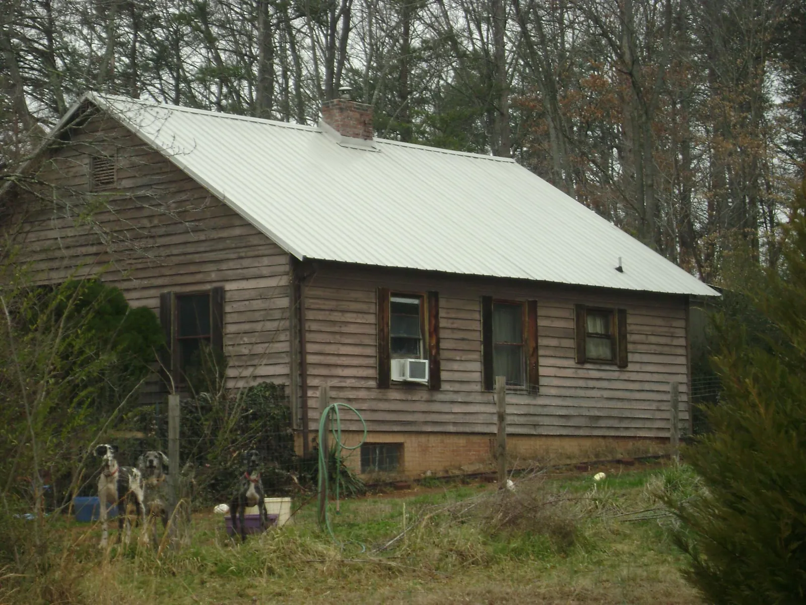 White metal roof on an old wood sided farmhouse, from a Metal Roof Installation job in Pleasant Garden